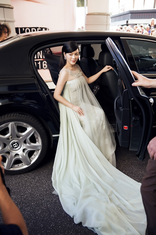 Người đẹp thu hút các ống kính ở cửa xe với bộ váy đuôi dài tha thướt. 