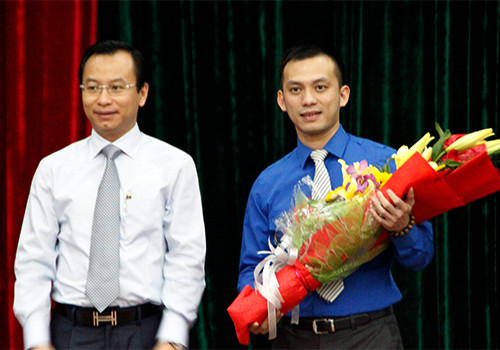 Ông Nguyễn Bá Cảnh (bìa phải) nhận hoa từ Bí thư Thành ủy Đà Nẵng tại buổi đối thoại với thanh niên tháng 3. Ảnh: N.Đ.