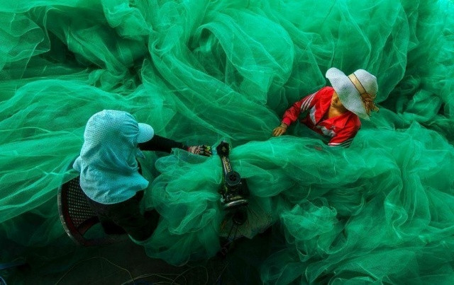 Phụ nữ Việt Nam may lưới đánh cá.