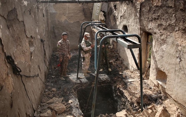 Các binh sĩ Iraq đang kiểm tra đường hầm dưới 1 tòa nhà bị phá hủy sau trận không kích ngày 28/4 tại làng Mahana, phía nam Mosul, Iraq.