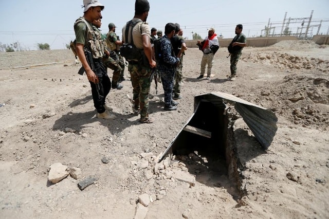 Các binh sĩ Iraq đứng cạnh lối ra của 1 đường hầm ở vùng ngoại ô Fallujah, Iraq.