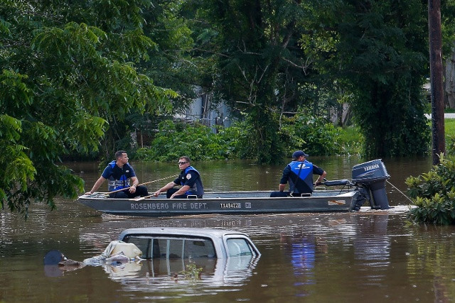 Các nhân viên cứu hỏa Rosenberg sử dụng cano để đi điều tra thiệt hại dọc 2 bờ sông Brazos sau khi lũ lụt nhấn chìm nhiều nhà cửa và xe cộ ở Richmond, bang Texas vào ngày 31/5. Ảnh: AP