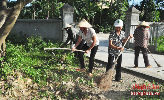 Học sinh và người dân tham gia vệ sinh môi trường tại nhà văn hóa và đường làng