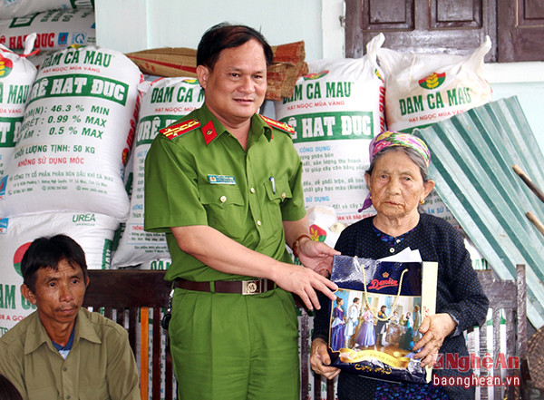 Đại tá Trần Thăng Long- Trưởng Công an huyện Quỳnh Lưu trao quyết định nhận phụng dưỡng Mẹ Việt Nam anh hùng cho Mẹ Vũ Thị Ngân.