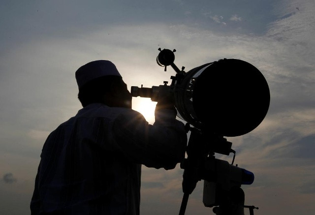 Một nam tín đồ quan sát mặt trăng qua kính viễn vọng trước khi chính thức bước vào tháng Ramadan truyền thống tại đền thờ Al-Musyariin ở Jakarta, Indonesia hôm 5/6.