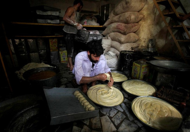 Trước đó, khắp nơi rộn ràng không khí chuẩn bị cho tháng lễ linh thiêng hàng năm. Trong ảnh: Anh thợ bánh cần mẫn nhào bột mỳ trước để chuẩn bị thực phẩm cho tháng Ramadan tại Peshawar, Pakistan hôm 31/5.