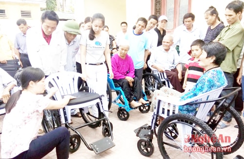Thành viên Hội Bảo trợ Người khuyết tật và Trẻ mồ côi Việt Nam hướng dẫn cách sử dụng xe lăn cho người khuyết tật.