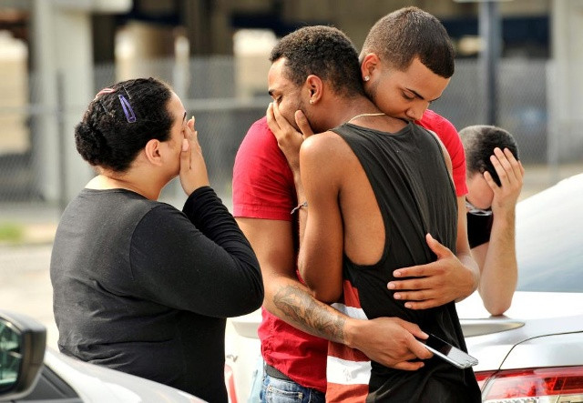Các nhóm bạn bè và người thân trong gia đình an ủi nhau bên ngoài trụ sở chính của cảnh sát Orlando trong lúc diễn ra điều tra vụ xả súng đẫm máu nhất lịch sử nước Mỹ.