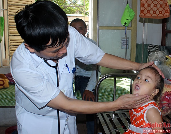 Bác sĩ Nguyễn Văn Sơn đang khám cho bệnh nhi bị quai bị.