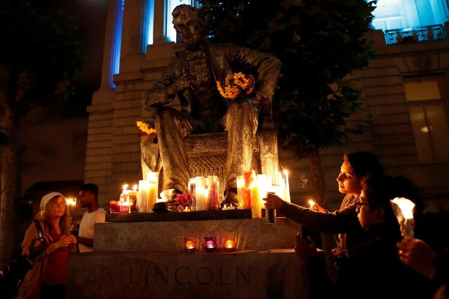 Người dân đặt nến dưới bức tượng nổi tiếng của Tổng thống Abraham Lincoln nhằm tưởng niệm những nạn nhân vô tội thiệt mạng trong vụ xả súng ở Orlando.