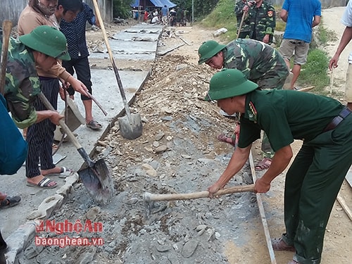 Cán bộ, chiến sỹ Đồn BP Tam Hợp giúp dân làm đường giao thông nông thôn. 