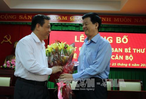 Ông Mai Văn Chính (bên phải) tặng hoa chúc mừng ông Nguyễn Trung Hiếu nhận nhiệm vụ m