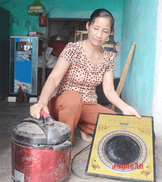 Chị Nguyễn Thị Hương và 2 sản phẩm nồi cơm điện, bếp hồng ngoại hiệu Madein China không thể sử dụng.