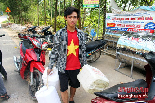 Một thanh niên người Khánh Sơn tranh thủ đi lấy nước sớm