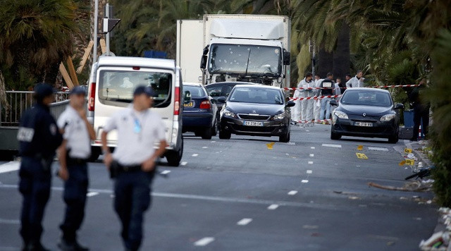 Cảnh sát điều tra chiếc xe tải trong vụ tấn công tại Nice sau khi bắn chết tài xế. Ảnh: Reuters)