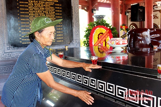 Cựu chiến binh Bùi Thị Chiến (63 tuổi, ở xã Xuân Hòa, Nam Đàn) xúc động khi được đặt tay lên mộ của 13 nữ TNXP.