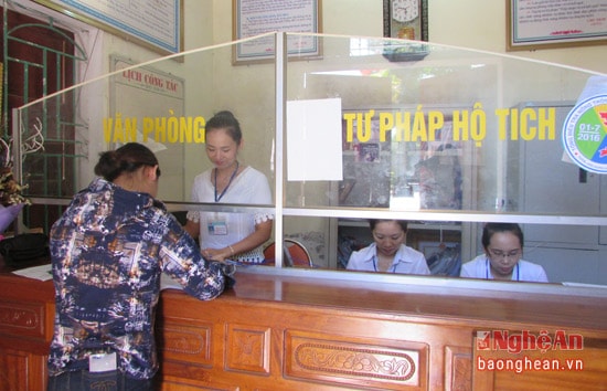 Cán bộ tại bộ phận “ một cửa” thị trấn Con Cuông hướng dẫn người dân làm các thủ tục.