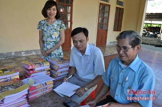 -Ông Bùi Mạnh Quỳnh ( ngoài cùng) nhận tài liệu, đề cương tuyên truyền miệng từ Ban Tuyên giáo huyện ủy.