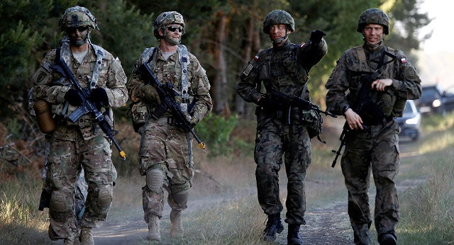 Binh lính Ba Lan đi tuần cùng binh lính Mỹ tại Torun, Ba Lan. Ảnh: Reuters.