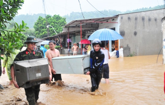Người dân Lào Cai di chuyển đồ đạc trong lũ lụt.