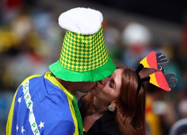 Cổ động viên hôn nhau trong buổi lễ khai mạc. Ảnh: Reuters