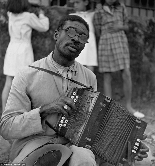 Một người đàn ông chơi chiếc accordion ngay giữa phiên chợ trời trong lòng thành phố.