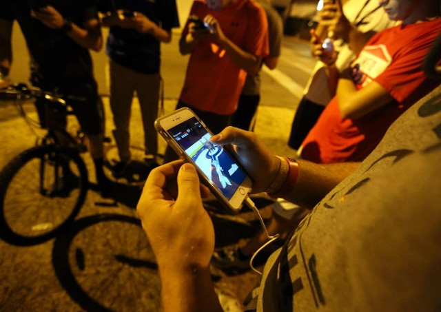 1 nhóm thanh niên đang tập trung chơi Pokémon GO. Ảnh: AP.