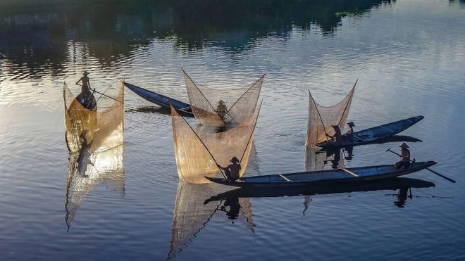 Khoảnh khắc các ngư dân đồng loạt thảlưới trên sông Hương ở Huế là thành quả của nhiếp ảnh Teberik Kolgeli. 