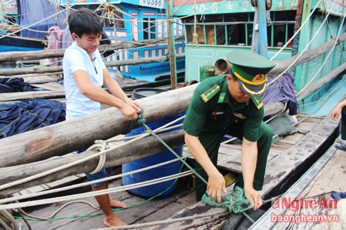 Cán bộ đồn biên phòng giúp ngư dân chằng néo tàu thuyền