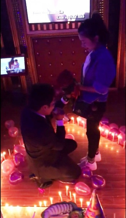 Chàng trai quỳ gối cầu hôn khiến cô gái vô cùng bất ngờ (Ảnh cắt từ clip).