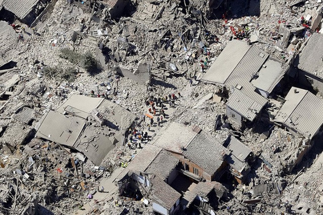 Thị trấn Amatrice ngập trong bụi xám và đống đổ nát, nhìn từ trên không. Thị trấn này chịu ảnh hưởng nặng nề nhất từ động đất. Ảnh: AP.