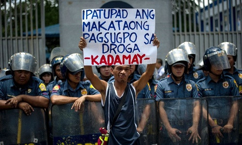 Một nhà hoạt động hôm 24/8 đứng trước trụ sở Cảnh sát Quốc gia Philippines và giơ cao tấm biển phản đối các vụ giết người không qua xét xử liên quan tới chiến dịch chống tội phạm ma túy do ông Rodrigo Duterte phát động. Ảnh: AFP