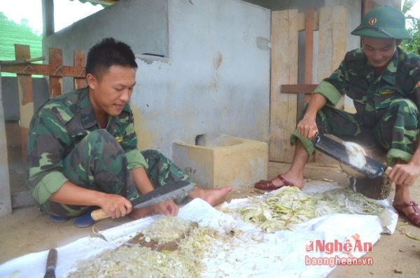 Cán bộ, chiến sỹ Đồn Biên phòng Phúc Sơn chuẩn bị thức ăn cho vật nuôi.