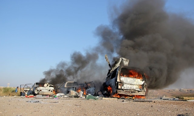 Ô tô bị cháy sau một cuộc không kích gần Hama, Syria. Ảnh: Anodoly Agency/Getty Images.