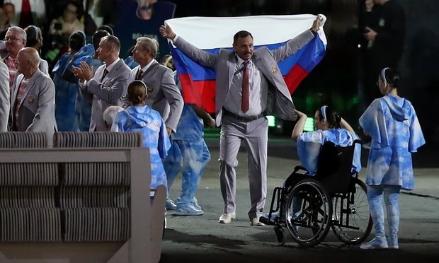 VĐV Belarus mang cờ Nga tới lễ khai mạc. Ảnh: The Guardian
