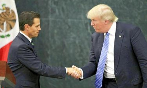 Tỷ phú Donald Trump bắt tay Tổng thống Enrique Pena Nieto trong chuyến thăm Mexico hôm 31/8. Ảnh: AP