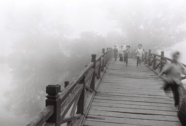 Những đứa trẻ nô đùa trên cầu Thê Húc dẫn vào đền Ngọc Sơn. Khi đó, cây cầu này màu đỏ son, làm bằng gỗ và có nhiều trụ liên tiếp.  