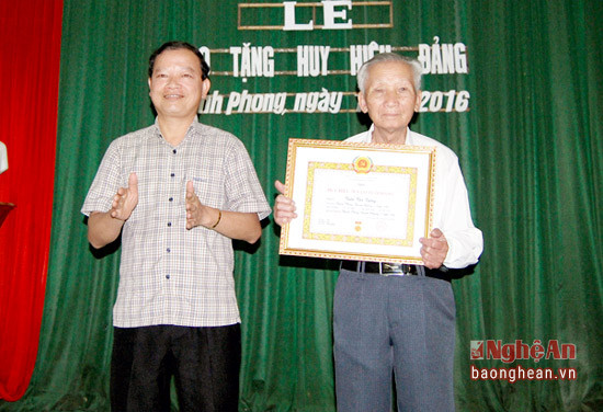 Đồng chí Nguyễn Hữu Vinh - Bí thư Huyện ủy, Chủ tịch HĐND huyện Thanh Chương dự và trao tặng Huy hiệu 70 năm tuổi Đảng cho đảng viên Trần Văn Tường ở Đảng bộ xã Thanh Phong. 