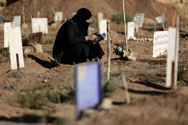Một phụ nữ Syria ngồi cầu nguyện bên mộ con trai trong ngày đầu tiên lệnh ngừng bắn có hiệu lực. Ảnh: AFP.