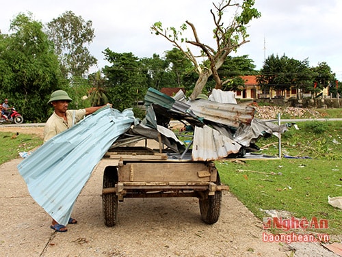 Người dân đi thu gom các tấm tôn lợp bị lốc cuốn bay