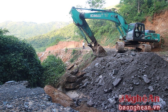 Tại bản Đai, xã Quế Sơn, nước lũ đã cuốn trôi làm đứt gãy một số đoạn đường, công nhân nhà máy thủy điện Nhạn Hạc đang điều khiển máy xúc để san lấp, nối lại con đường.