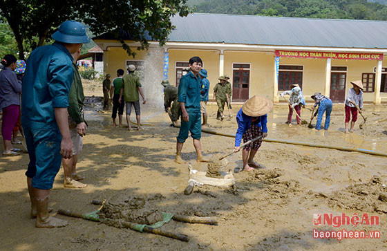 Phụ huynh, người dân địa phương và các đoàn viên đang dọn vệ sinh tại khuôn viên trường.