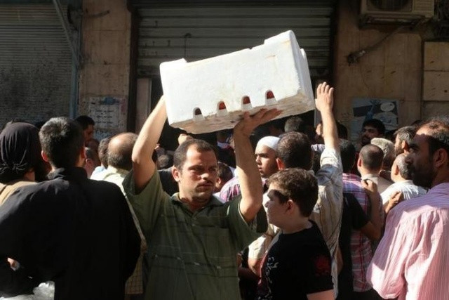 Người dân Aleppo, Syria nhận thực phẩm cứu trợ. Ảnh: Reuters.