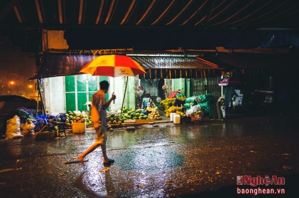 Trước sạp hàng hoa quả đêm mưa. Ảnh: Sách nguyễn