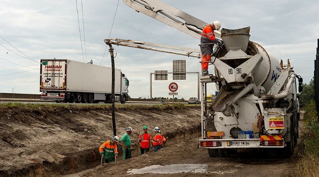 Công nhân đang đổ bê tông xây dựng bức tường thành gần trại tị nạn ở Calais. Ảnh: AFP.