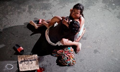 Một phụ nữ ôm chặt xác người chồng bị bắn chết trên đường phố Philippines vì tình nghi buôn bán ma túy. Ảnh: Reuters
