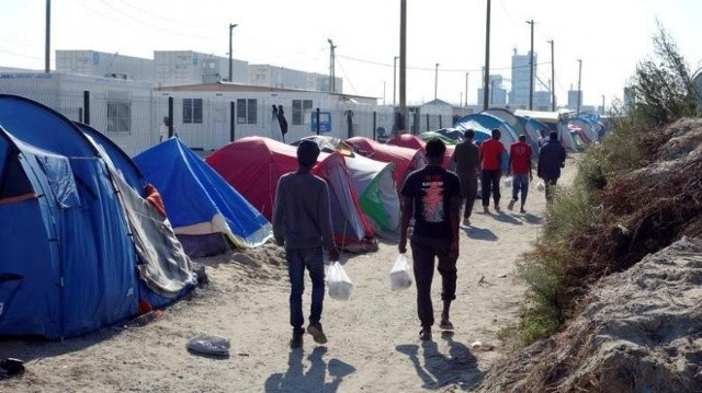Người tị nạn đi bộ trong khu trại tị nạn được gọi là “Rừng” (Jungle) ở ngoại ô Calais, Pháp. (Nguồn: Reuters)