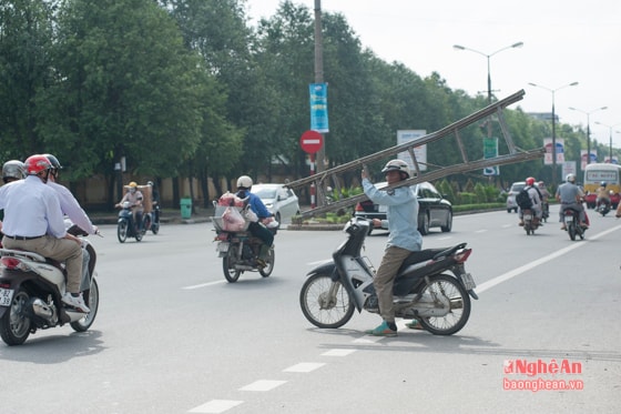 Tại ngã ba cây xăng QK4, người đàn ông này đang chuẩn bị qua đường với một chiếc thang cồng khềnh trên vai và dường như có thể mất thăng bằng bất cứ lúc nào. 