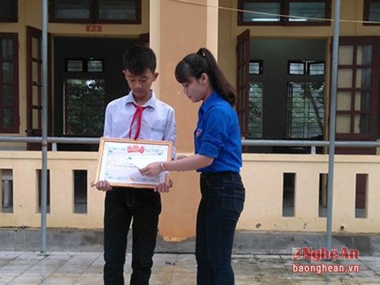 Đại diện huyện đoàn Diễn Châu tặng giấy khen cho em Đặng Minh Sơn đã có hành động dũng cảm cứu hai em nhỏ bị đuối nước
