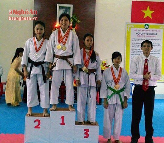 Khánh Linh đứng trên bục nhận Huy chương vàng trong hội thi các câu lạc bộ mạnh karatedo toàn tỉnh